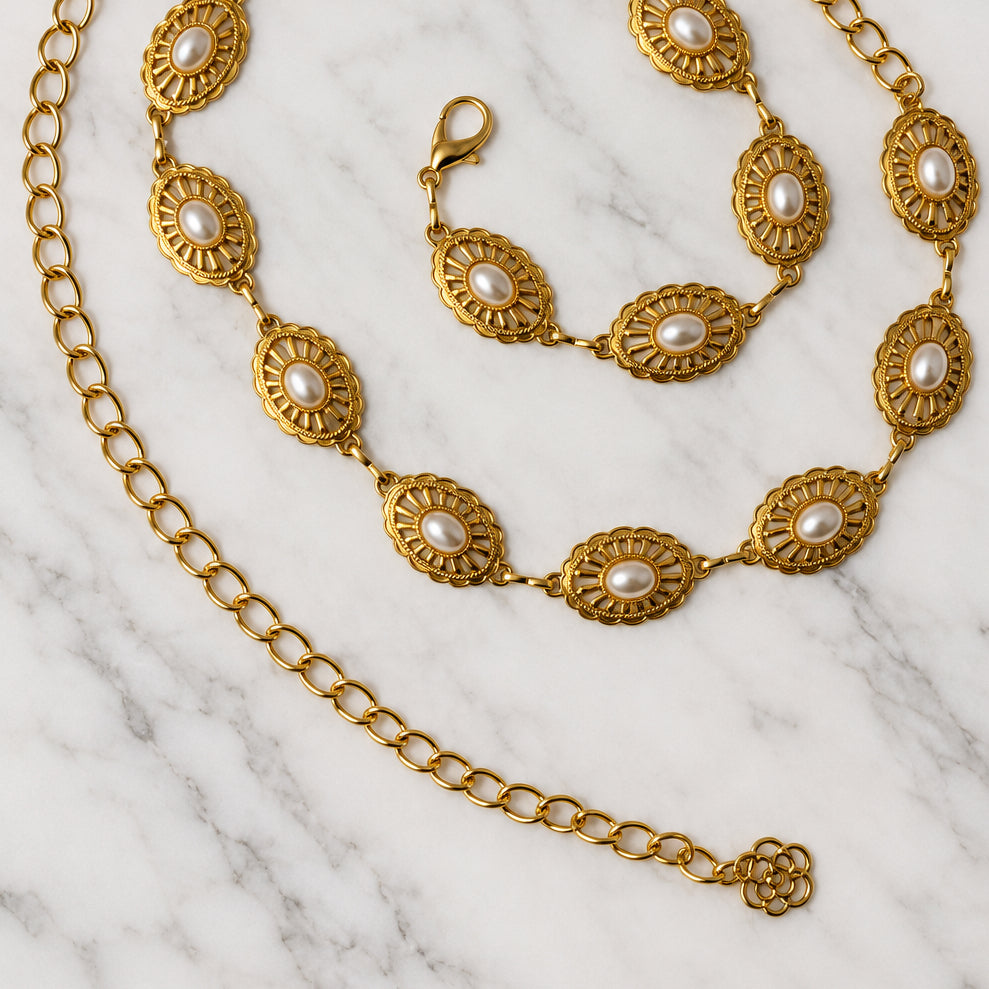 Gold-tone pearl medallion waist chain coiled in a spiral, showing oval pearl medallions etched with a sunburst pattern, faux pearls, a lobster clasp and a flower charm