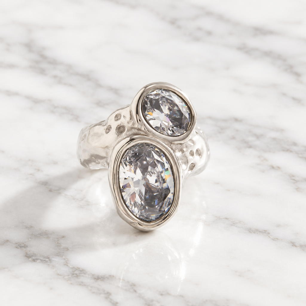 Chunky silver-tone open ring with a hammered texture and two large clear oval faceted stones set diagonally.