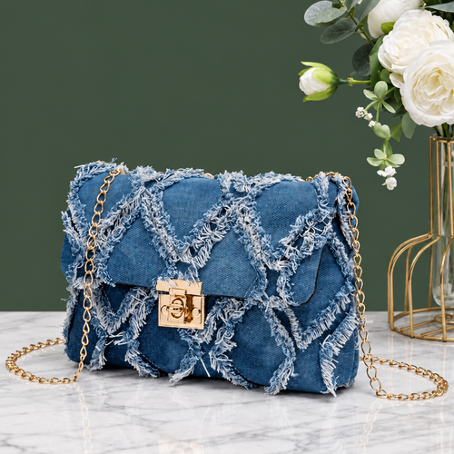 Small rectangular blue denim-look crossbody bag with a diamond-quilted pattern, frayed edges, gold-tone push-lock closure and gold-tone chain strap.