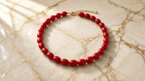 Candy Apple Game Day Necklace on cream marble with gold veining