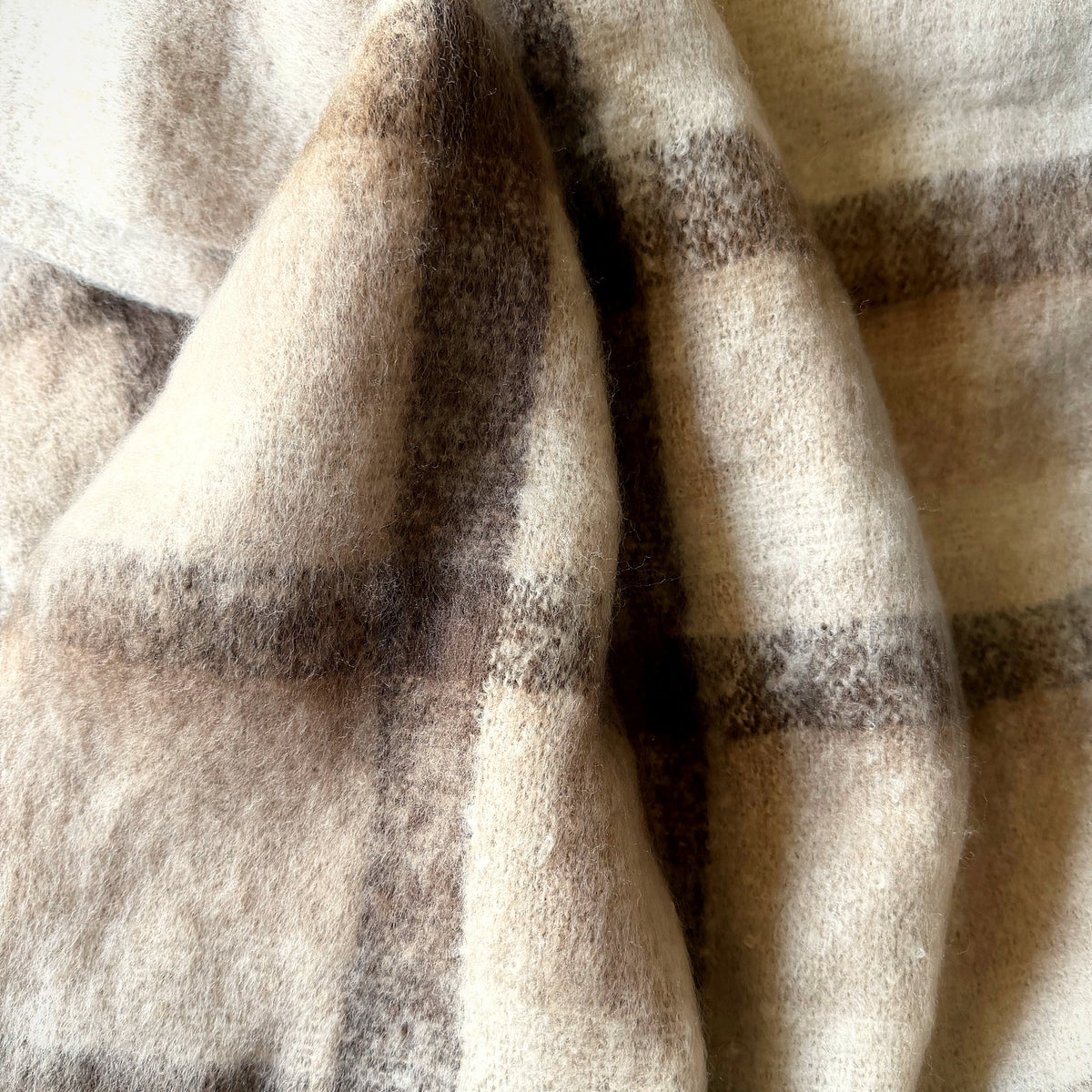 Close-up of soft brushed cream and cocoa plaid blanket scarf fabric