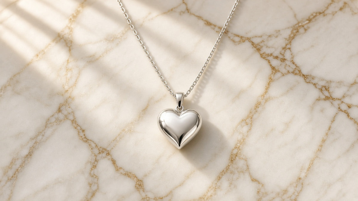 Puffy Heart Sterling Silver Necklace on cream marble with gold veining