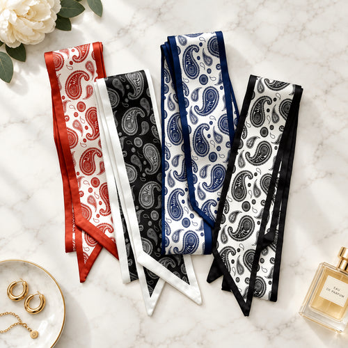 Four paisley twilly scarves in rust, black with white border, navy and black on white marble.