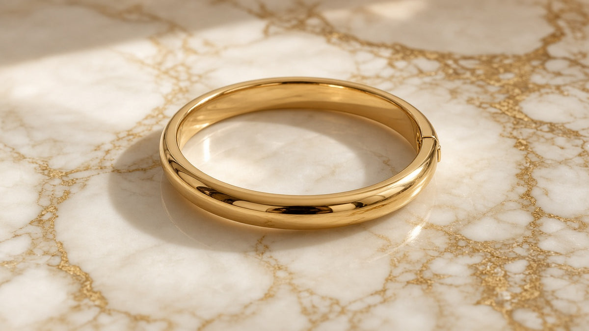 Golden Hour Snap Bangle on cream marble with gold veining