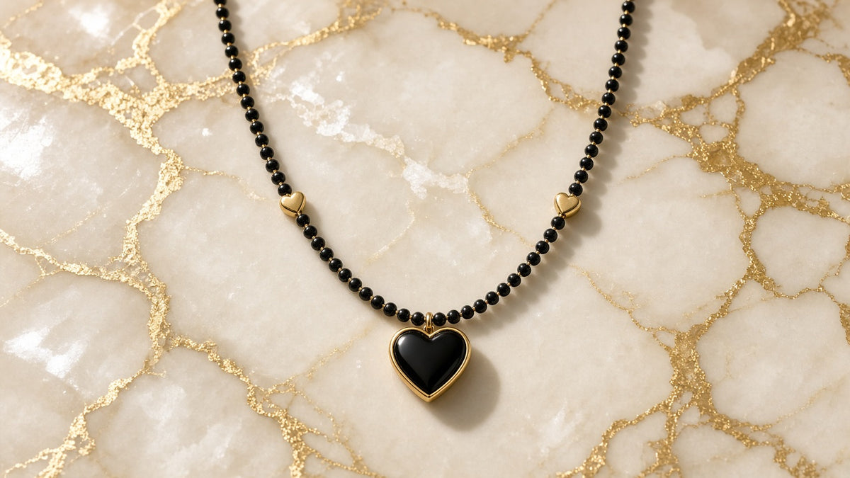 Noir Heart Beaded Necklace on cream marble with gold veining